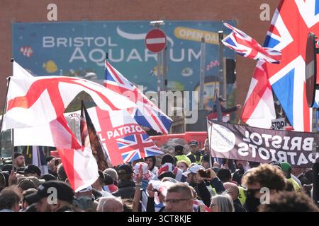 Bristol, Regno Unito. 5 ottobre 2025. I patrioti di destra con le bandiere di San Giorgio e dell'Unione si riuniscono al Cenotafio di Bristol, per protestare contro l'immigrazione. Gli attivisti, molti che si identificano come antifascisti, che credono che migranti e rifugiati debbano essere accolti, hanno organizzato una contro-protesta. Avon e la polizia di Somerset hanno adottato misure per consentire una protesta pacifica, ma intendono tenere tutti al sicuro tenendo separate le due parti. Crediti: JMF News/Alamy Live News Foto Stock