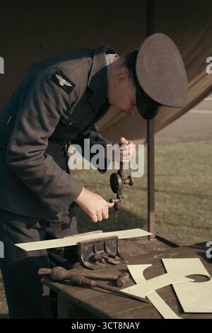 Addetto alla manutenzione della RAF per la foratura uniforme del legno con utensili manuali presso il museo degli aeromobili Foto Stock