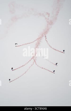 RAF Red Arrows squadra acrobatica che esegue voli di formazione con piste colorate di fumo a Duxford Foto Stock
