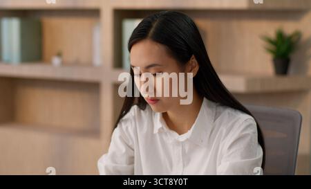 Concentrata donna d'affari asiatica coreana donna d'affari professionale leader capo giapponese donna d'affari cinese lavoratrice d'ufficio che lavora online Foto Stock
