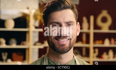 Primo piano ritratto felice sorridente uomo caucasico imprenditore uomo uomo uomo uomo uomo d'affari uomo scultore ceramista che guarda la macchina fotografica sorridere negozio di ceramiche al chiuso Foto Stock