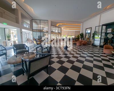 Vista ad ampio angolo di una spaziosa ed elegante lobby di lusso con un impressionante pavimento a scacchi bianco e nero. Interni dal design moderno e contemporaneo Foto Stock