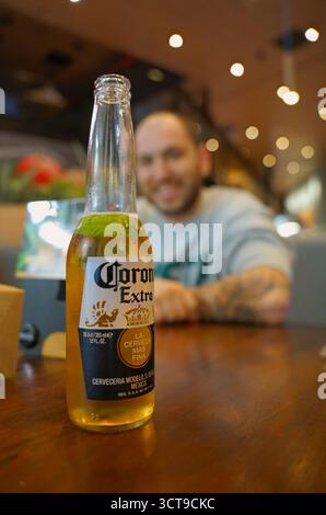 Sorseggiate un drink rinfrescante in un ristorante vivace durante un pomeriggio di sole con gli amici Foto Stock
