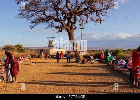 Gli abitanti del villaggio Maasai in Kenya vendono oggetti d'artigianato ai turisti, stimolando la loro economia e condividendo la loro cultura. Foto Stock