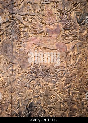 Primo piano verticale di una scena dell'antica mitologia buddista sui rilievi murali del tempio all'interno del tempio di Angkor Wat, in Cambogia Foto Stock
