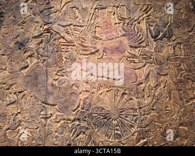 Gli antichi rilievi murali del tempio all'interno di Angkor Wat, in Cambogia, raffigurano battaglie storiche e scene della mitologia buddista. Foto Stock