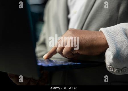 Primo piano del programmatore nel data center digitando sulla tastiera del notebook, scrivendo righe di codice. Esperto IT della sala server che utilizza script di programmazione su laptop e esegue la diagnostica sull'infrastruttura Foto Stock