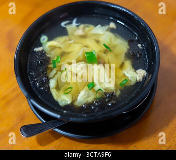 La zuppa di wonton è composta da gnocchi cotti ripieni di carne o pesce. Vengono serviti in brodo, solitamente arricchiti con cipolle e altri ingredienti. Cinese Foto Stock