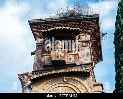 Primo piano di un burattino animato che suona il campanello in cima alla Torre dell'orologio pendente a Tbilisi, Georgia, che mette in mostra la cura artigianale dettagliata e il design stravagante Foto Stock