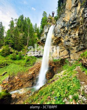 La bellezza della cascata di Johannes vicino a Obertauern, Austria. Circondata da una vegetazione lussureggiante, la cascata scende lungo le scogliere rocciose, offrendo panorami mozzafiato Foto Stock