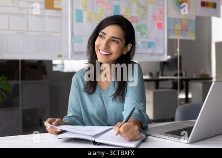 Giovane manager latino positivo che lavora in ufficio Foto Stock