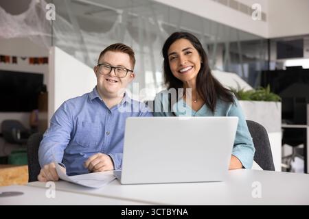 Due colleghi professionisti felici e diversificati che lavorano per un'azienda inclusiva Foto Stock