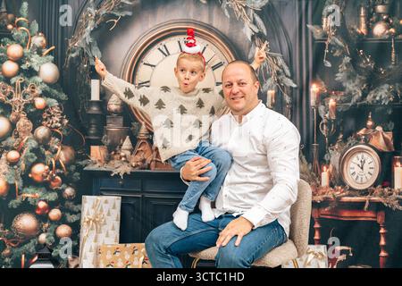 Gioiosa interazione con la famiglia catturata in un movimento natalizio, eccitazione e sincera emozione. Ideale per marchi di giocattoli, promozioni per feste e famiglie Foto Stock