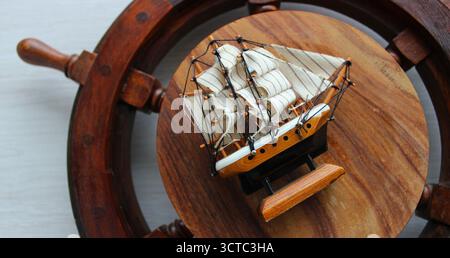 Flat è un'immagine dettagliata di una statuetta di una nave a vela sulla ruota di una vera nave vecchia Foto Stock