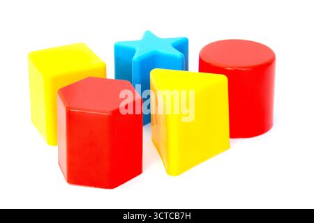 Cinque forme di plastica in blu, rosso e giallo su sfondo bianco Foto Stock