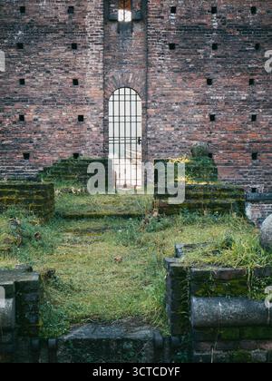 Ponte antico verso una piccola porta del castello alla luce della sera Foto Stock
