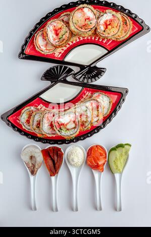 Sushi roll al salmone con ingredienti su sfondo bianco isolato Foto Stock