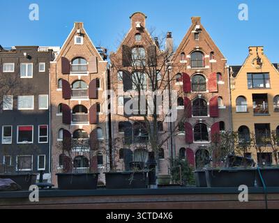 Primo piano delle tradizionali case sui canali di Amsterdam - vista frontale di una fila di storiche case sui canali olandesi con gradini e architettura distinta, S. Foto Stock