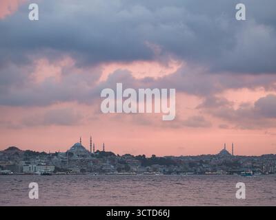 Skyline di Istanbul al crepuscolo rosa - spettacolare cielo crepuscolo rosa e viola sopra lo storico skyline di Istanbul, con moschee illuminate e minare Foto Stock