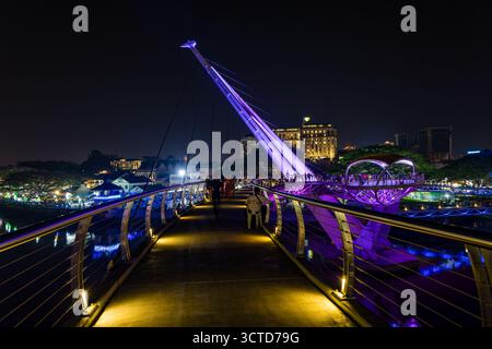Moderno e illuminato Darul Hana Bridge sul lungomare di Kuching di notte a Sarawak. Foto Stock