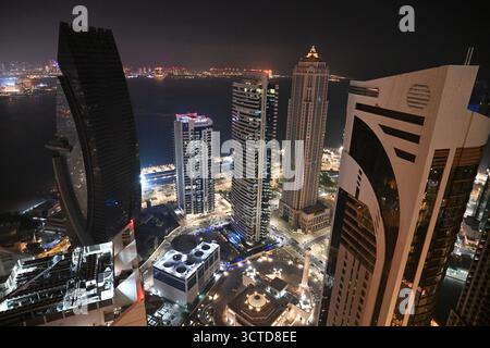 Qatar, Doha: Vista notturna del quartiere degli affari di West Bay e dei suoi grattacieli, nel cuore della baia, lungo la Corniche, che ospita vari corpor Foto Stock