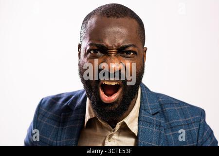 Primo piano ritratto di un uomo d'affari afroamericano arrabbiato che guarda la macchina fotografica e urla. Foto Stock