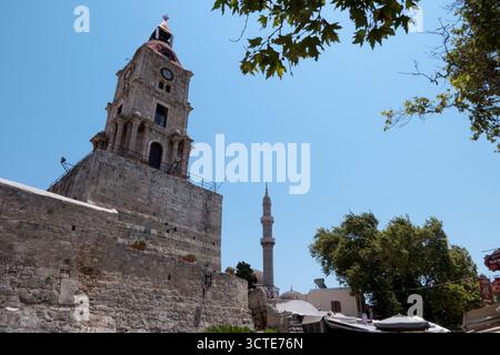 Vista della città vecchia di Rodi, Grecia, con persone, monumenti e vecchi edifici. Chiesa e moschea città medievale greca in estate. Patrimonio mondiale dell'UNESCO Foto Stock