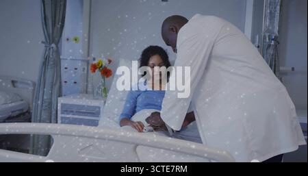 Medico esaminante appoggiato sul letto d'ospedale, controllo braccio paziente con abito blu e fiori Foto Stock