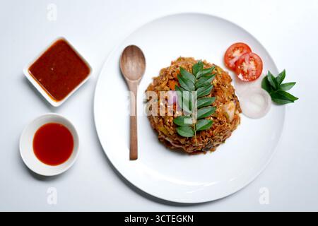 Pollo piccante Kottu Roti servito su piatto bianco. Foto Stock