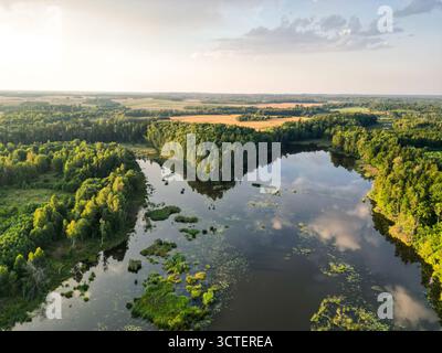 Una splendida vista aerea della tranquilla campagna lettone nella regione di Semigallia (Zemgale) al tramonto. Foto Stock