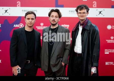 Berlino, Germania. 6 ottobre 2025. Leon Döhner (l-r), produttore, nominato nella categoria No Fear - Bernd Eichinger Award (Skin on Skin), Simon Schneckenbauer, regista, nominato nella categoria dei lungometraggi medi (Skin on Skin), e Nico Schrenk, direttore della fotografia, nominato nella categoria Michael Ballhaus Award (Skin on Skin), si alzano prima della presentazione del First Steps Newcomer Award al Theater des Westens. Crediti: Sebastian Christoph Gollnow/dpa/Alamy Live News Foto Stock
