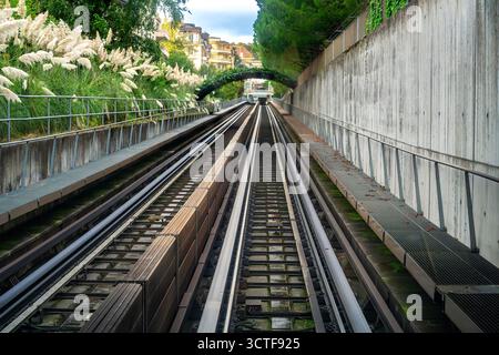 Binari ferroviari della metropolitana di Losanna che conducono ad un tunnel circondato dal verde. Foto Stock