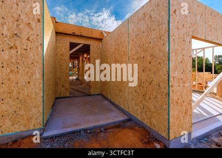 I lavoratori sono impegnati nella costruzione di una casa, mentre le pareti aprono gli spazi durante la costruzione di una nuova casa Foto Stock