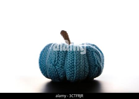 Una sola zucca blu lavorata a mano su sfondo bianco e pulito che simboleggia il raccolto autunnale, le vacanze autunnali e Halloween. Intima decorazione minimalista con Foto Stock