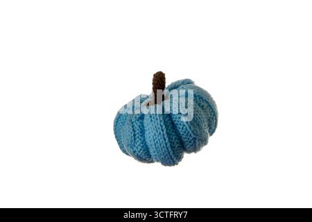 Piccola zucca blu a maglia isolata su sfondo bianco con illuminazione soffusa, ideale per decorazioni autunnali, artigianato accogliente e prodotti tessili fatti a mano p Foto Stock