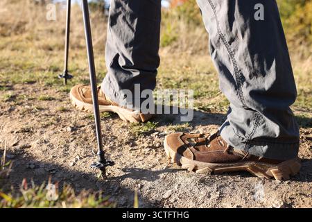 Escursionista con bastoni da trekking camminando all'aperto nelle giornate di sole, primo piano Foto Stock