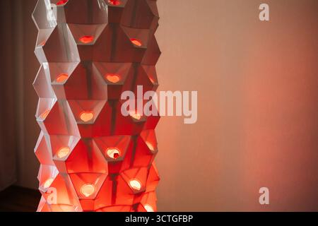 Moderna torre idroponica verticale con luci rosse, struttura geometrica illuminante che mette in risalto l'innovativa tecnologia agricola per interni Foto Stock