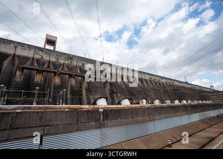 Itaipu Binacional, Brasile - 22 giugno 2025: La base della struttura della diga, evidenziando la scala della centrale elettrica e del canale idrico adiacente. Foto Stock