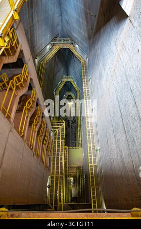 Itaipu Binacional, Brasile - 22 giugno 2025: Spettacolare vista sul profondo interno della struttura della diga di Itaipu, che mostra massicce pareti in cemento e muratura Foto Stock