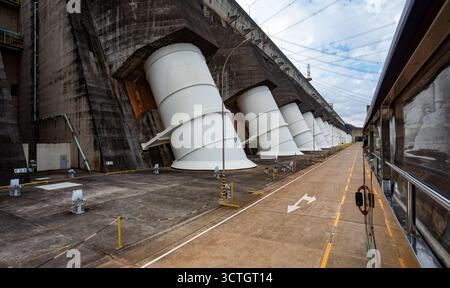 Itaipu Binacional, Brasile - 22 giugno 2025: Una serie di tubi di pescaggio giganti sporgono dalla faccia in cemento della centrale idroelettrica di Itaipu Foto Stock