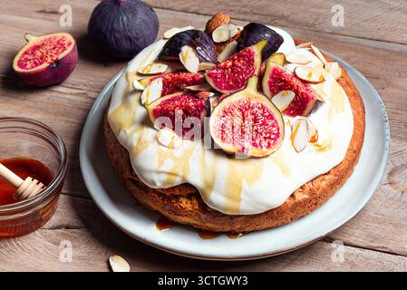 Torta di mandorle con fichi, formaggio cremoso montato e miele. Ricetta per dolci di stagione fatti in casa per le vacanze autunnali. Foto Stock