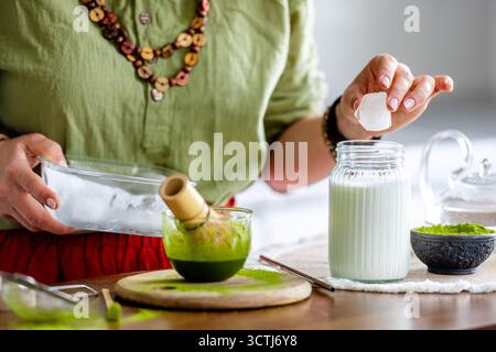 Donna che prepara il tè verde Matcha con un primo piano di ghiaccio Foto Stock