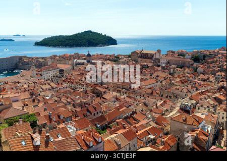 Esplora i vivaci tetti rossi della città vecchia di Dubrovniks contro il mare cristallino. Foto Stock