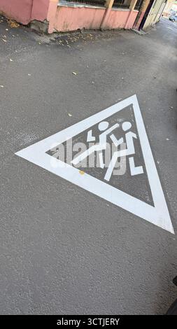 Segnale di attraversamento pedonale dipinto sul marciapiede urbano che trasmette un messaggio di sicurezza. Foto mobile Foto Stock