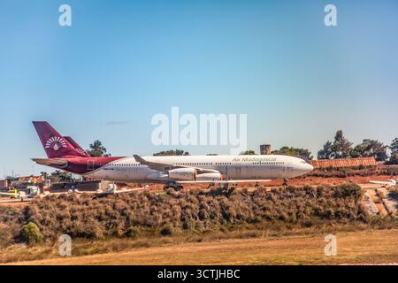 Antananarivo, Madagascar - 5 ottobre 2023: Air Madagascar Aircraft è parcheggiato sulla pista con cielo blu e paesaggio sullo sfondo. Foto Stock
