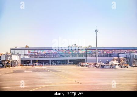 Antananarivo, Madagascar - 5 ottobre 2023: Moderno terminal aeroportuale con colorata facciata in vetro e vista asfalto. Foto Stock