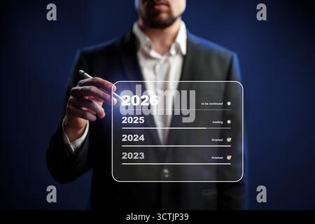 Pianificazione futura visualizzata da un uomo che scrive su uno schermo digitale in un ambiente buio Foto Stock