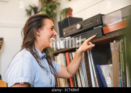 giovane donna che mette su un disco in vinile a casa Foto Stock