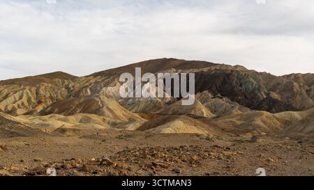 Colline multicolore nel 20 Mule Team Canyon della Death Valley con profonde scanalature, foreground roccioso e vividi strati di sedimenti modellati dall'erosione. Foto Stock