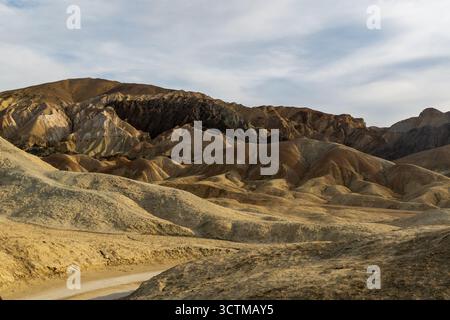 Colline multicolore nel 20 Mule Team Canyon della Death Valley con profonde scanalature, foreground roccioso e vividi strati di sedimenti modellati dall'erosione. Foto Stock